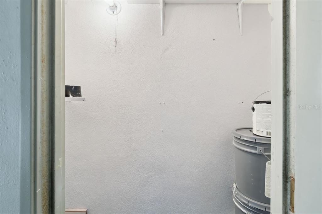 A small, white-walled storage closet contains a shelf and stacked plastic buckets — 8215 SUN SPRING CIRCLE UNIT 12, ORLANDO, FL