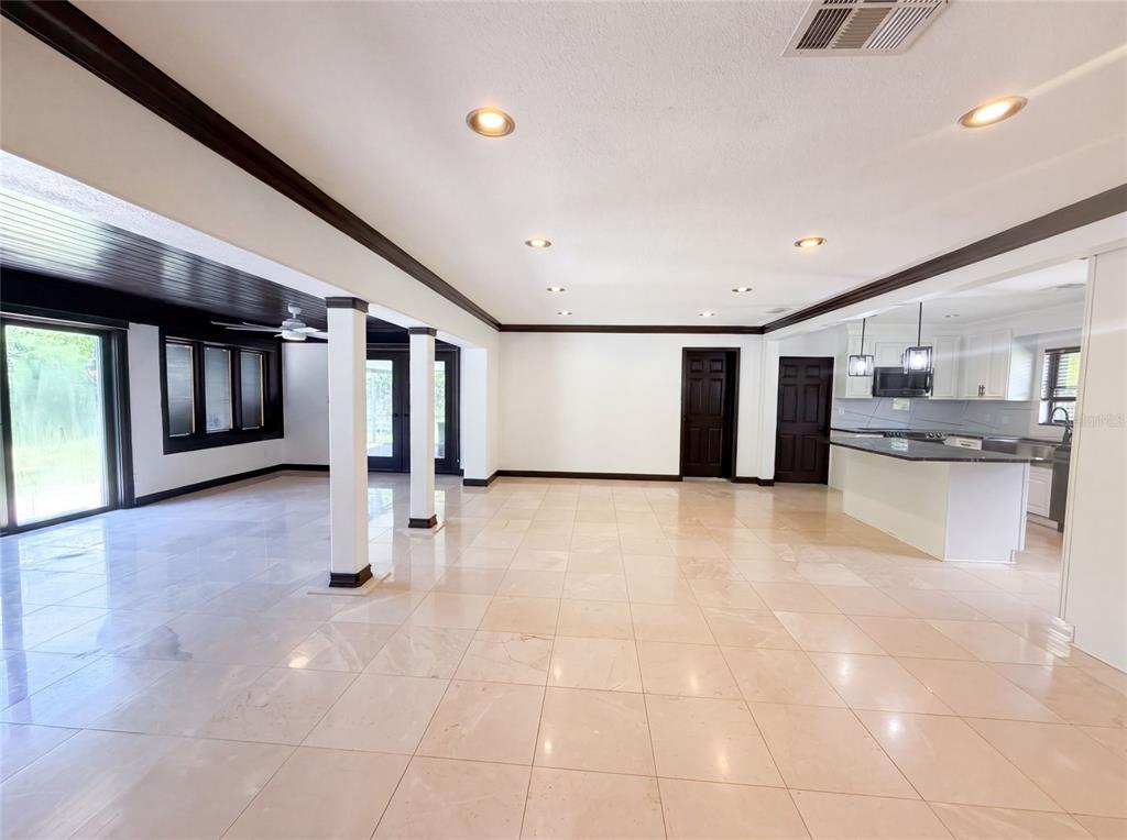 An open-concept living area with light tile flooring, white walls, and a kitchen island — 1515 S WEST SHORE BOULEVARD, TAMPA, FL
