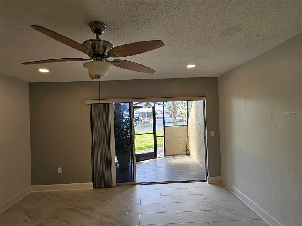 A living room with tile flooring, a ceiling fan, and sliding doors opening to a patio — 1028 APOLLO BEACH BOULEVARD UNIT 19, APOLLO BEACH, FL