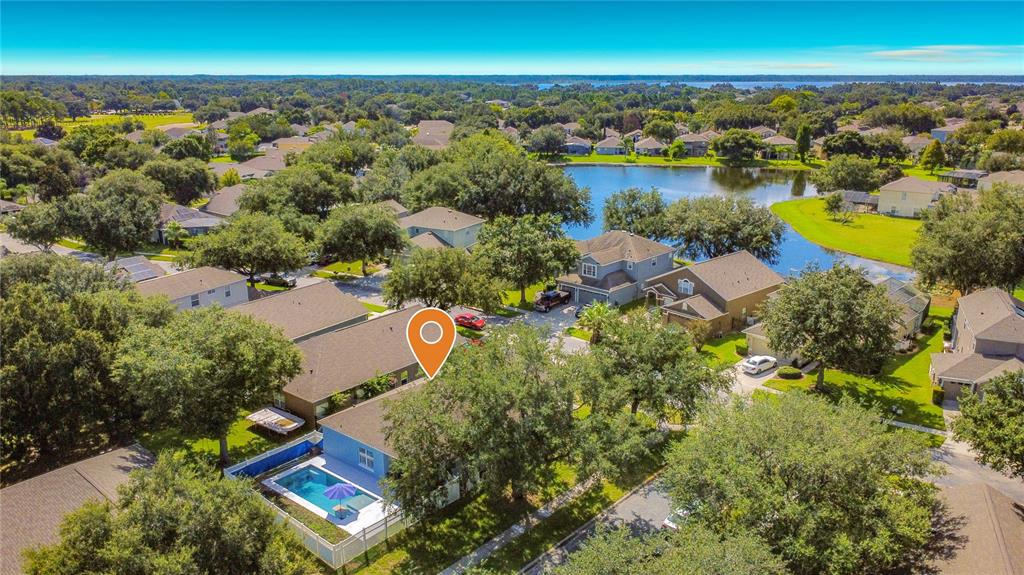 An aerial view of a suburban house with a backyard swimming pool and a lake — 9850 HIDDEN DUNES LANE, ORLANDO, FL