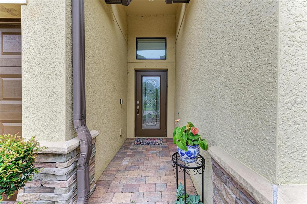 A front entryway features a brown door with a glass insert, a transom window, and pavers — 3512 SAVANNA PALMS COURT, LAKEWOOD RANCH, FL