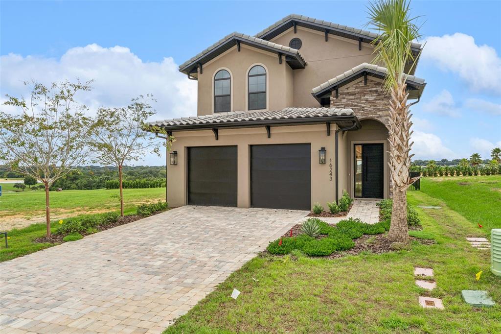 A two-story house with a tile roof, stone accents, and a two-car garage — 16243 VETTA DRIVE, MONTVERDE, FL