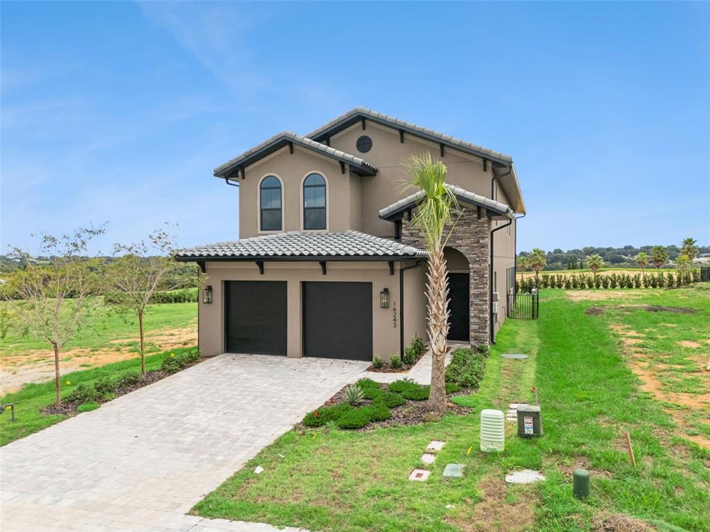 A view of a golf course with a paved tee box and distant water feature — 16243 VETTA DRIVE, MONTVERDE, FL