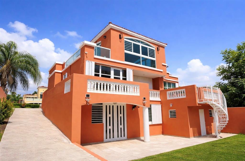 A three-story orange house with a white balcony, spiral staircase, and a concrete driveway — The Village at the Hill FLAMENCO UNIT 50, CEIBA, PR