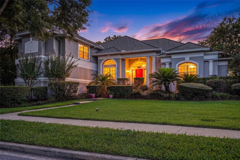 A two-story house with a gray exterior, a red front door, and a manicured lawn — 600 CHOCKTAW STREET, LAKE MARY, FL