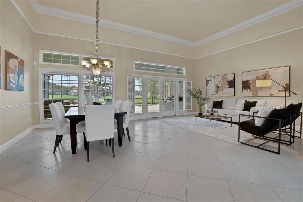 A bright living room features tile floors, a chandelier, and glass doors leading outside — 600 CHOCKTAW STREET, LAKE MARY, FL