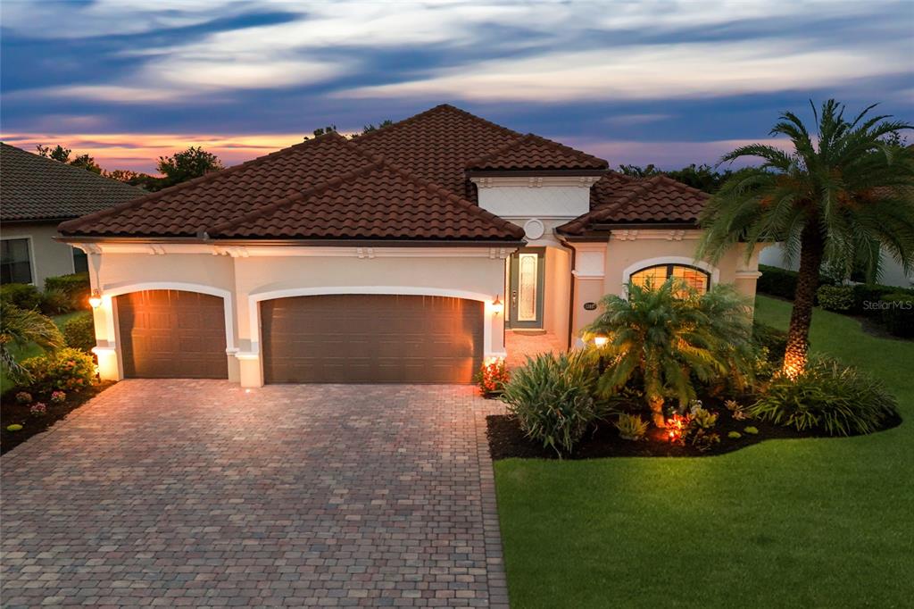 A single-story house with a tiled roof, a brick paver driveway, and a three-car garage — 13017 RAMBLEWOOD TRAIL, BRADENTON, FL