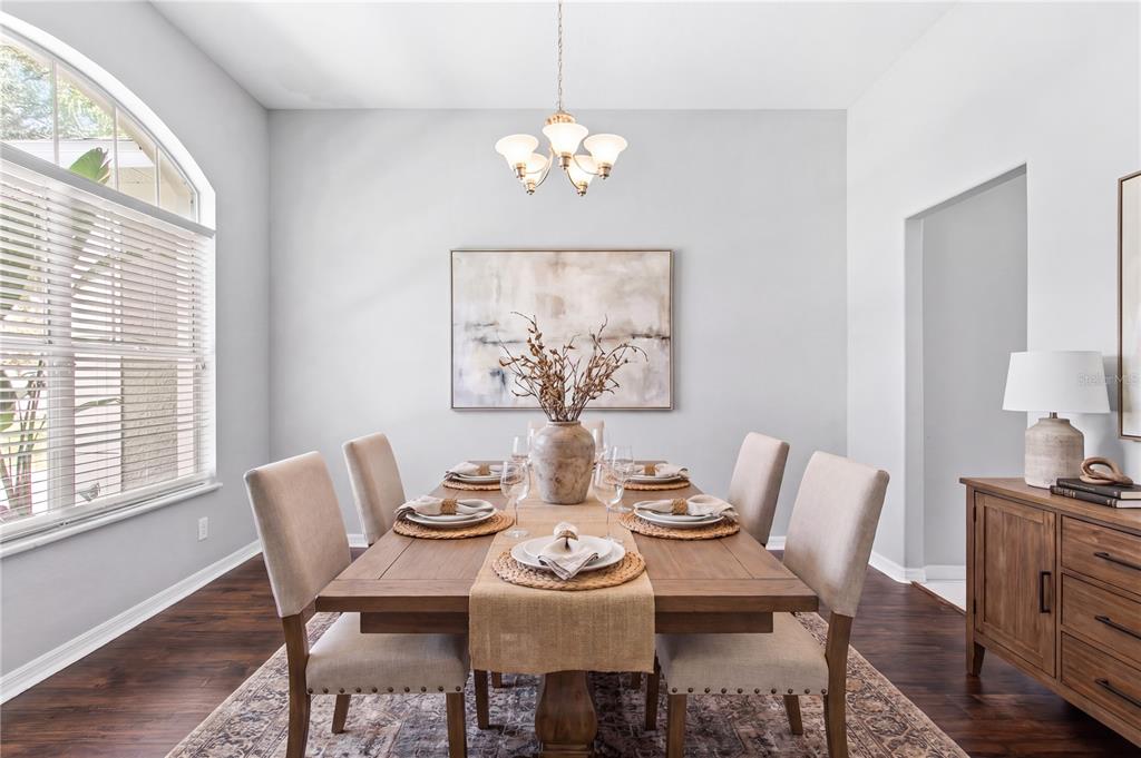 A dining room with a wooden table, six upholstered chairs, and a central light fixture — 1604 LORIANA STREET, BRANDON, FL