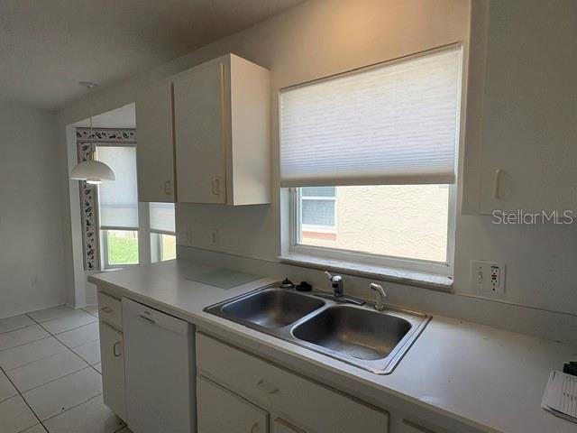 A kitchen features white cabinets, a double-basin stainless steel sink, and a window with blinds — 505 CEDAREDGE DRIVE, NEW SMYRNA BEACH, FL
