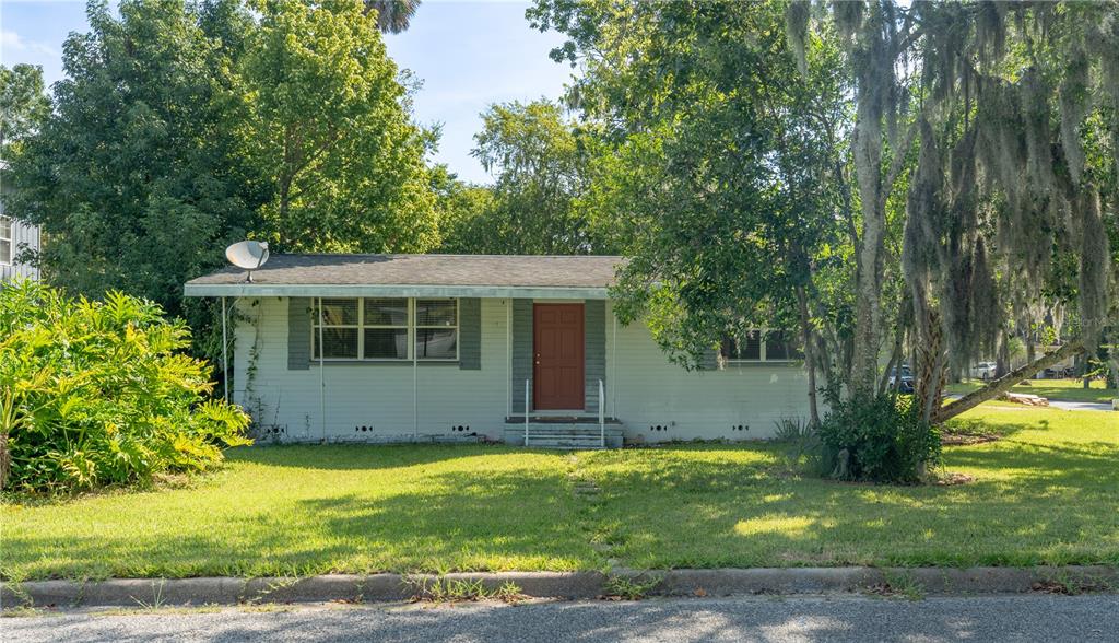 A single-story house with light siding, a red front door, and a satellite dish — 553 S LANVALE AVENUE, DAYTONA BEACH, FL