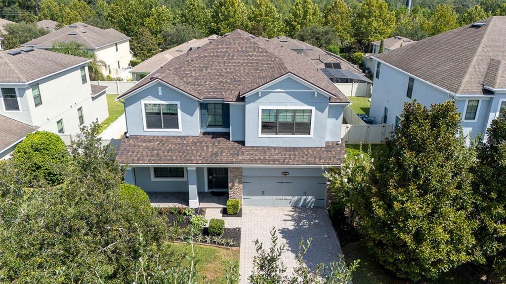 An aerial view of a two-story blue house with a brown shingled roof and driveway — 5728 RUE GALILEE LANE, SANFORD, FL