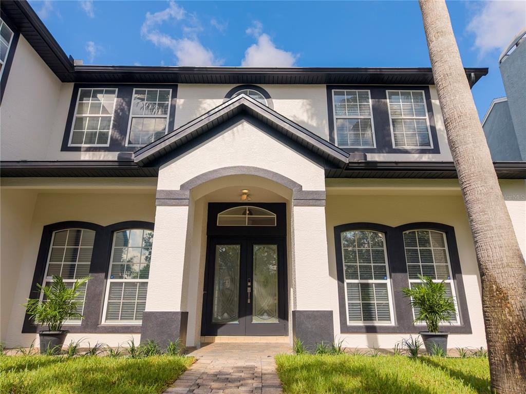 A two-story house with a cream stucco exterior, dark trim, and a double front door — 13138 PALOMA DRIVE, ORLANDO, FL