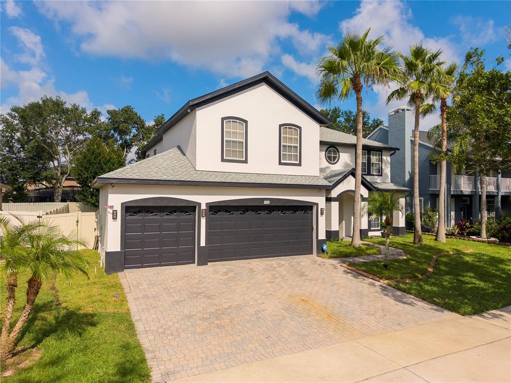 A two-story house with a white stucco exterior, dark trim, and a two-car garage — 13138 PALOMA DRIVE, ORLANDO, FL