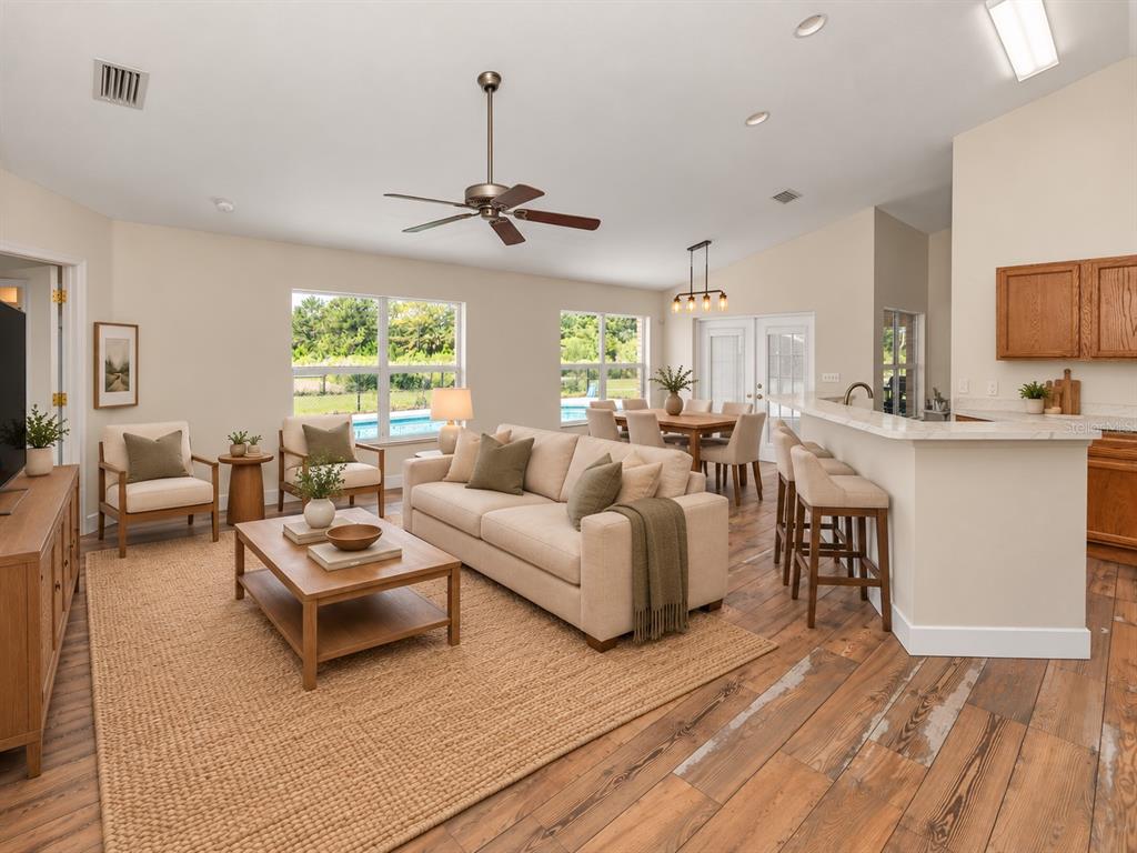 A kitchen with wood cabinets, white countertops, stainless steel appliances, and wood-look tile flooring — 1005 WHISPRING CREEK WAY, OSTEEN, FL