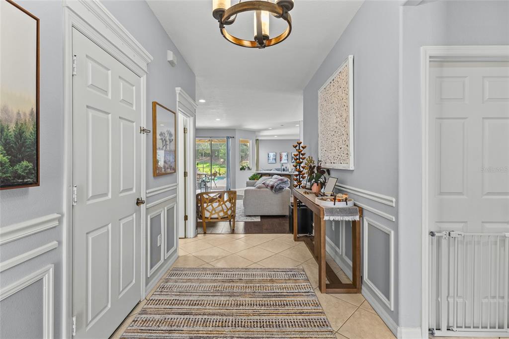 A tiled entryway leads into a living area with a console table and area rug — 14229 CATTLE EGRET PLACE, LAKEWOOD RANCH, FL