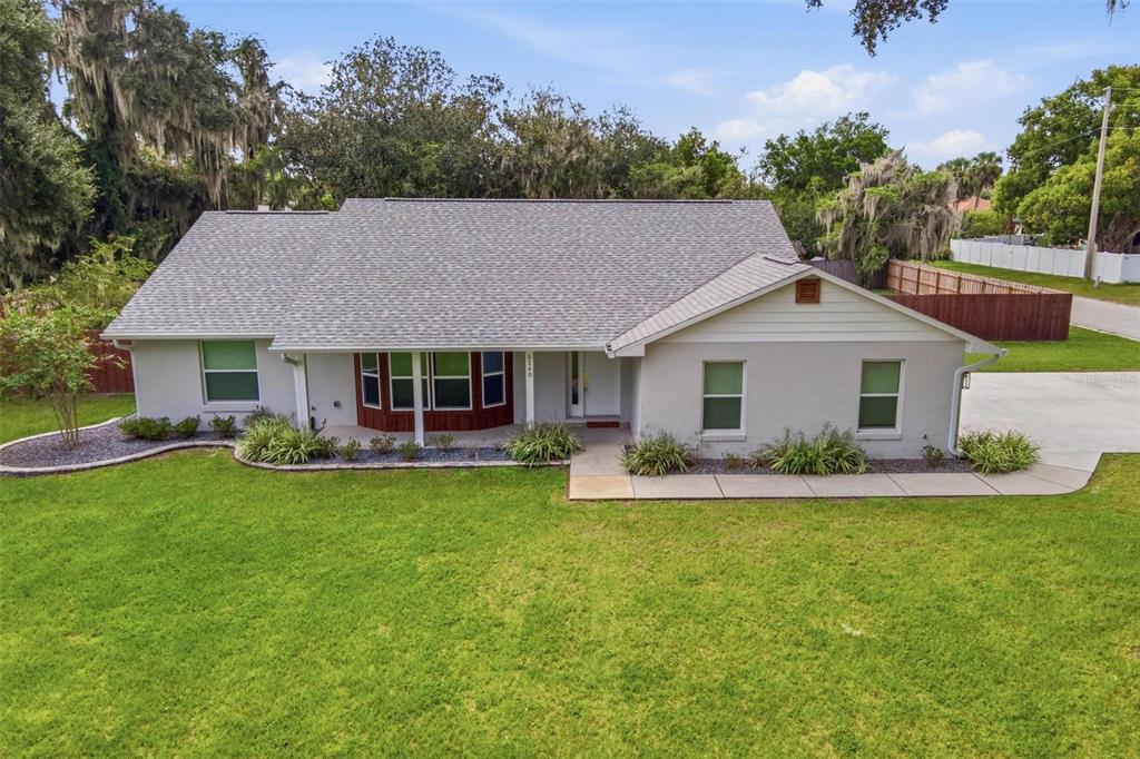 A single-story house with a gray shingled roof, light gray brick exterior, and a front lawn — 5240 ROYAL OAK DRIVE, FRUITLAND PARK, FL