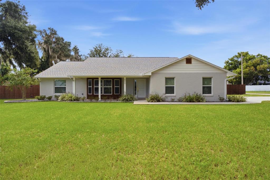 A single-story house with a light gray exterior, a shingled roof, and a large front lawn — 5240 ROYAL OAK DRIVE, FRUITLAND PARK, FL