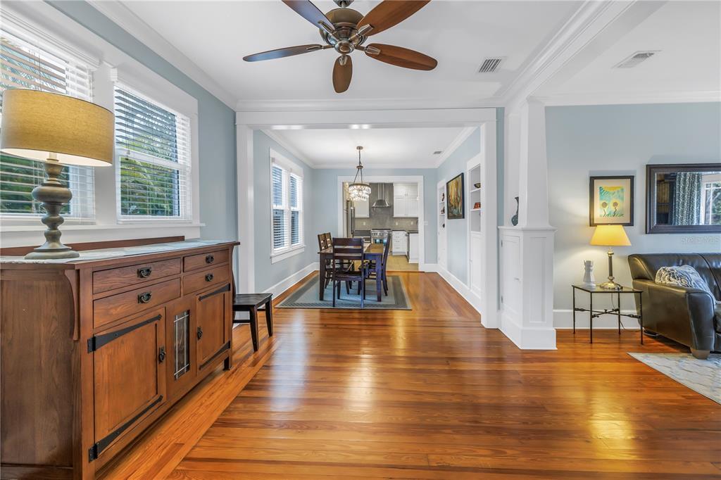 A living room with hardwood floors leads into a dining area and kitchen — 436 12TH AVENUE NE, ST PETERSBURG, FL