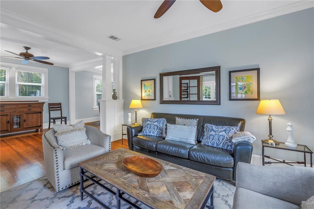 A living room features a dark leather sofa, two gray armchairs, and a wooden coffee table — 436 12TH AVENUE NE, ST PETERSBURG, FL