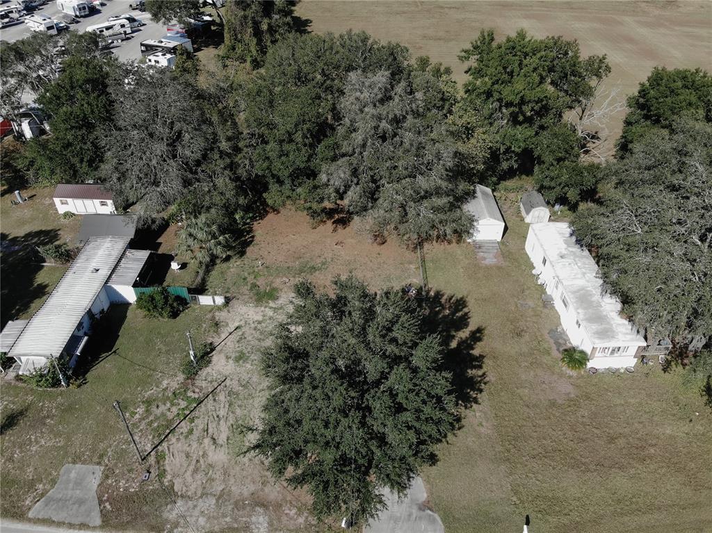 An aerial view shows two mobile homes on a wooded lot with several small outbuildings — 9251 SE 140TH PLACE, SUMMERFIELD, FL