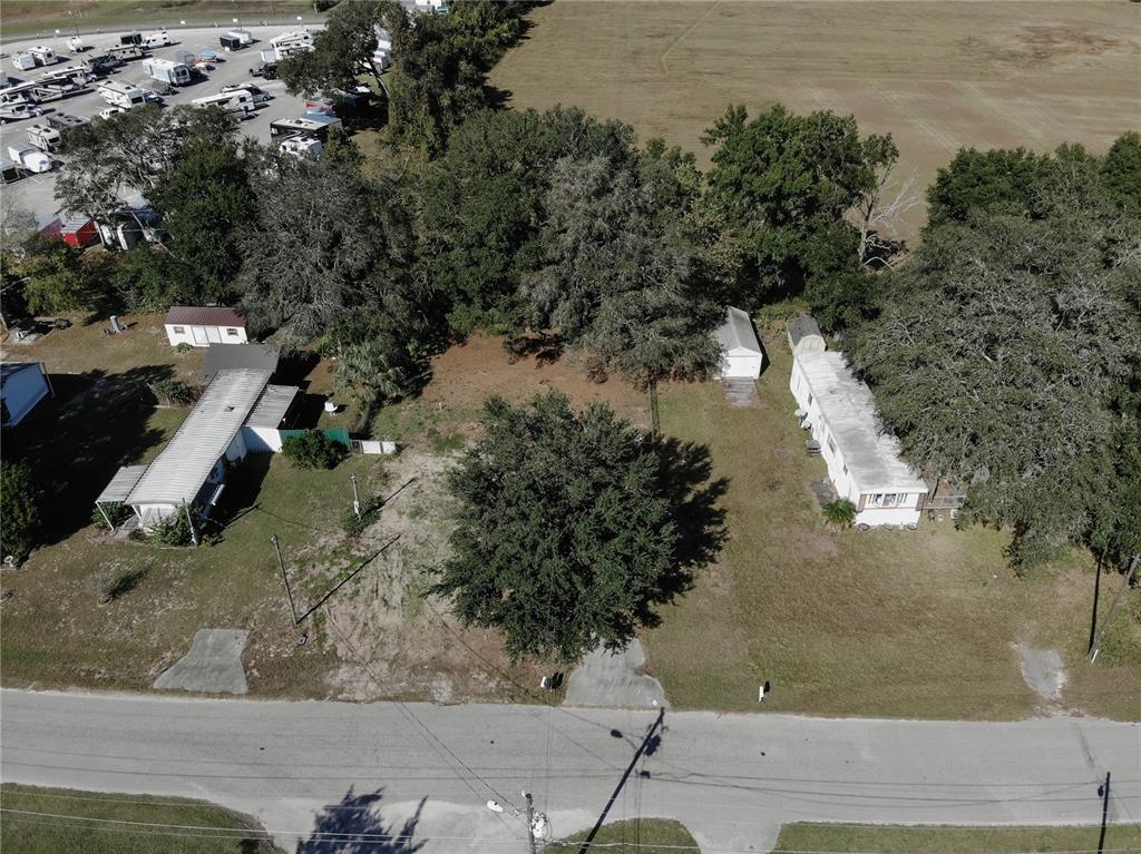 An aerial view shows two mobile homes on a grassy lot with trees and pavement — 9251 SE 140TH PLACE, SUMMERFIELD, FL