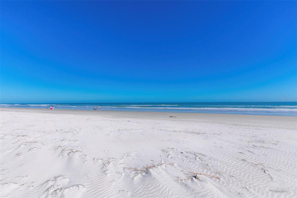 A wide, sandy beach meets the ocean under a clear blue sky — 4873 S ATLANTIC AVENUE, PONCE INLET, FL