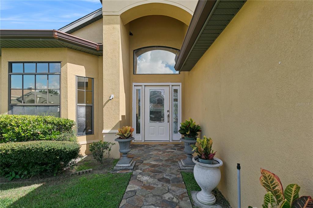 The exterior of a house features a stone walkway leading to a white front door — 509 HARDWOOD CIRCLE, ORLANDO, FL