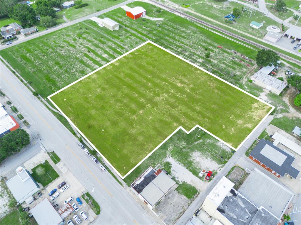 An aerial view shows a large, vacant, grass-covered lot outlined in white — N SCENIC HIGHWAY, FROSTPROOF, FL