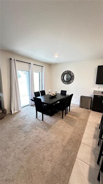 A kitchen island with a sink and dishwasher faces a dining area and living room — 476 BOARDWALK AVENUE, HAINES CITY, FL