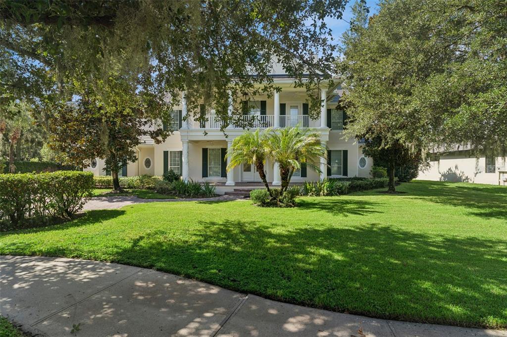 A two-story Southern colonial style house with a columned front porch and a large lawn — 1516 SUNSET POINTE PLACE, KISSIMMEE, FL