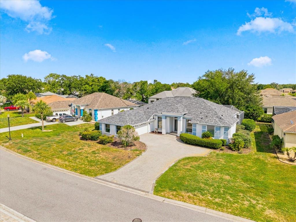 An aerial view of a single-story suburban house with a paved driveway and shingled roof — 8402 MAYBELLE DRIVE, WEEKI WACHEE, FL