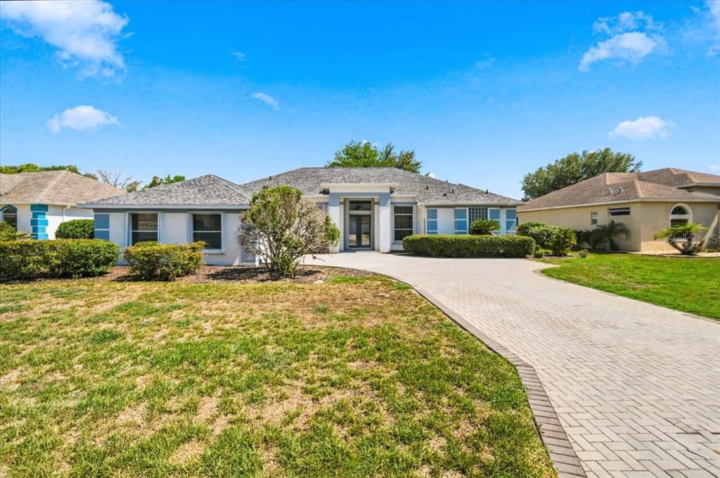 A single-story house with a gray shingled roof and a paved driveway — 8402 MAYBELLE DRIVE, WEEKI WACHEE, FL
