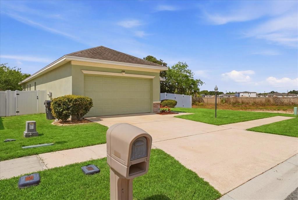 A beige house with a two-car garage and a mailbox in the foreground — 1789 KINGSMILL DRIVE, BARTOW, FL