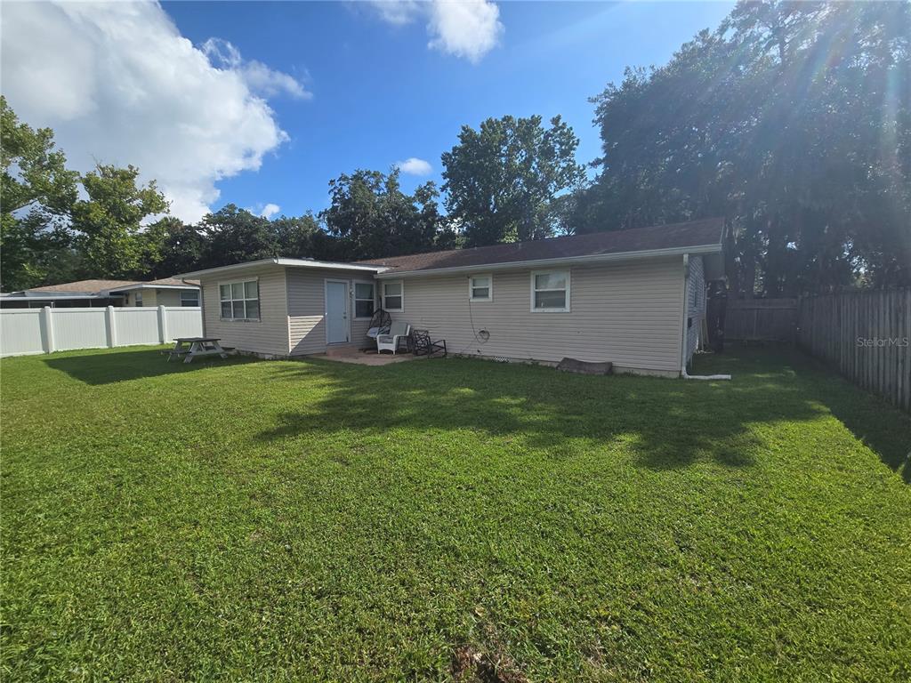 A view of the backyard and the rear exterior of a single-story house — 340 S CENTER STREET, ORMOND BEACH, FL