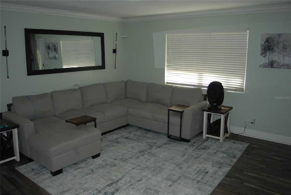 A living room features a large gray sectional sofa, a patterned rug, and a mirror — 340 S CENTER STREET, ORMOND BEACH, FL