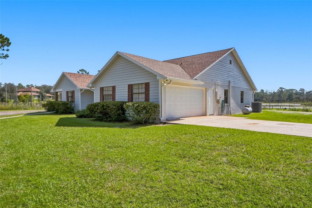 A paved driveway transitions into a dirt path winding through a wooded area with palmettos — 349 SEMINOLE WOODS BLVD, GENEVA, FL