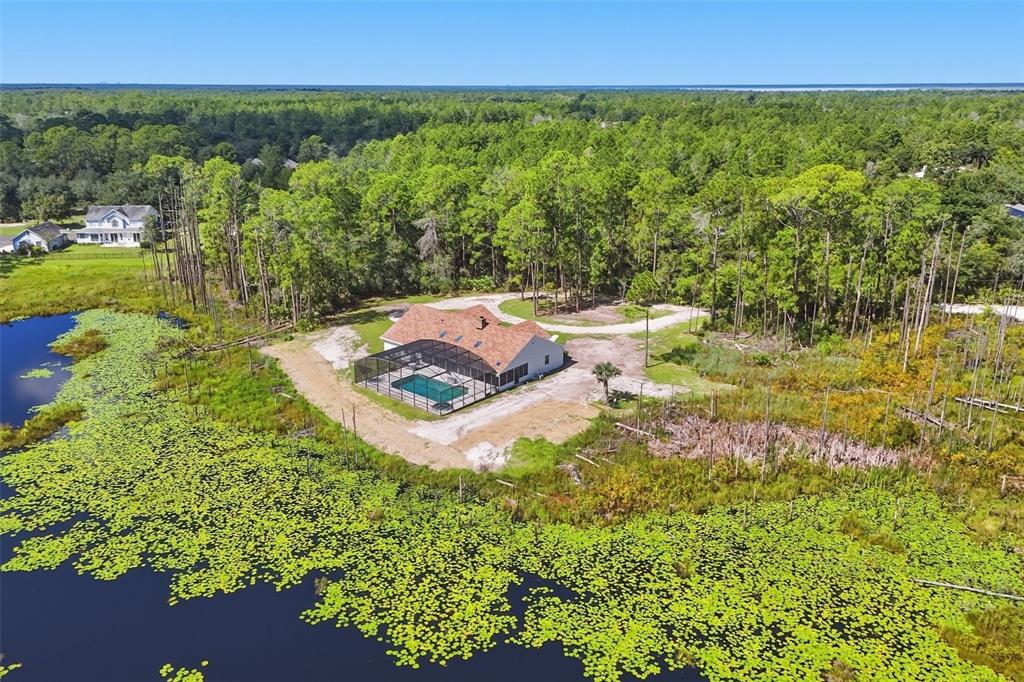 A one-story house with tan siding, brick accents, and a concrete walkway leading to the entrance — 349 SEMINOLE WOODS BLVD, GENEVA, FL