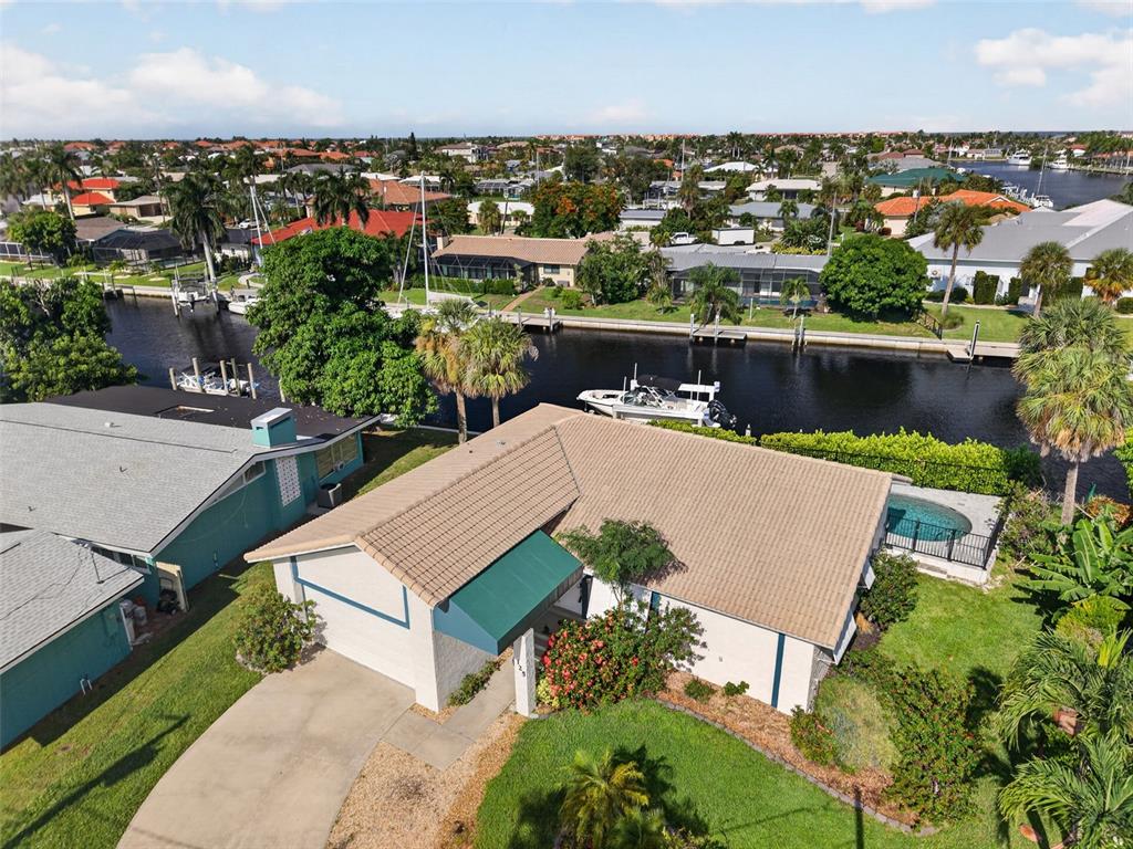 An aerial view shows a waterfront house with a boat dock along a canal — 125 DONNA COURT, PUNTA GORDA, FL