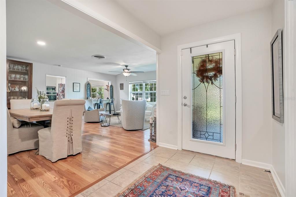 An entryway with tile flooring leads into a dining area and living room with hardwood floors — 1224 DUNCAN AVENUE, LAKELAND, FL