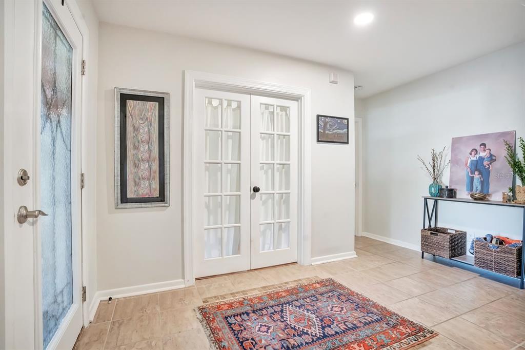 An entryway with tile flooring, a patterned rug, French doors, and a console table — 1224 DUNCAN AVENUE, LAKELAND, FL
