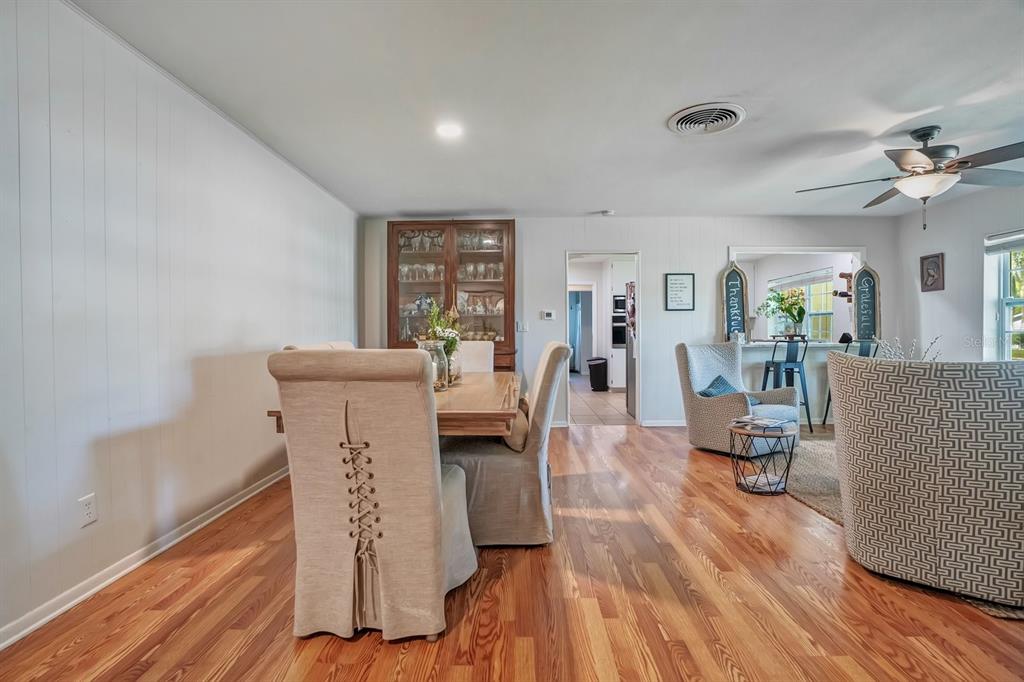 A dining area with wood floors, a wooden hutch, and upholstered chairs with corset-style backs — 1224 DUNCAN AVENUE, LAKELAND, FL
