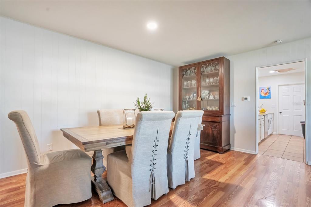 A dining room features a wooden table, upholstered chairs, and a tall wooden china cabinet — 1224 DUNCAN AVENUE, LAKELAND, FL