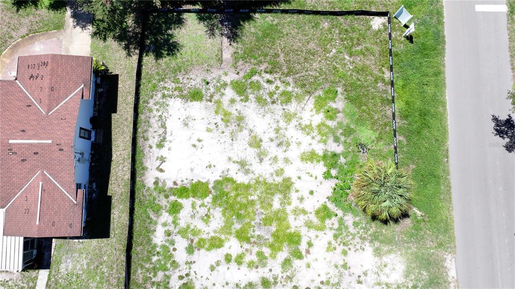 An aerial view shows a vacant, fenced-in residential lot next to an existing house — 5631 23RD AVENUE S, GULFPORT, FL