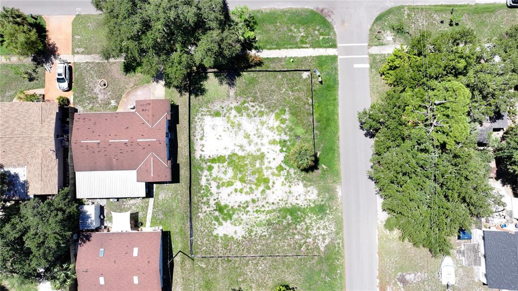 An aerial view shows a vacant, fenced residential lot situated between two houses and a street — 5631 23RD AVENUE S, GULFPORT, FL