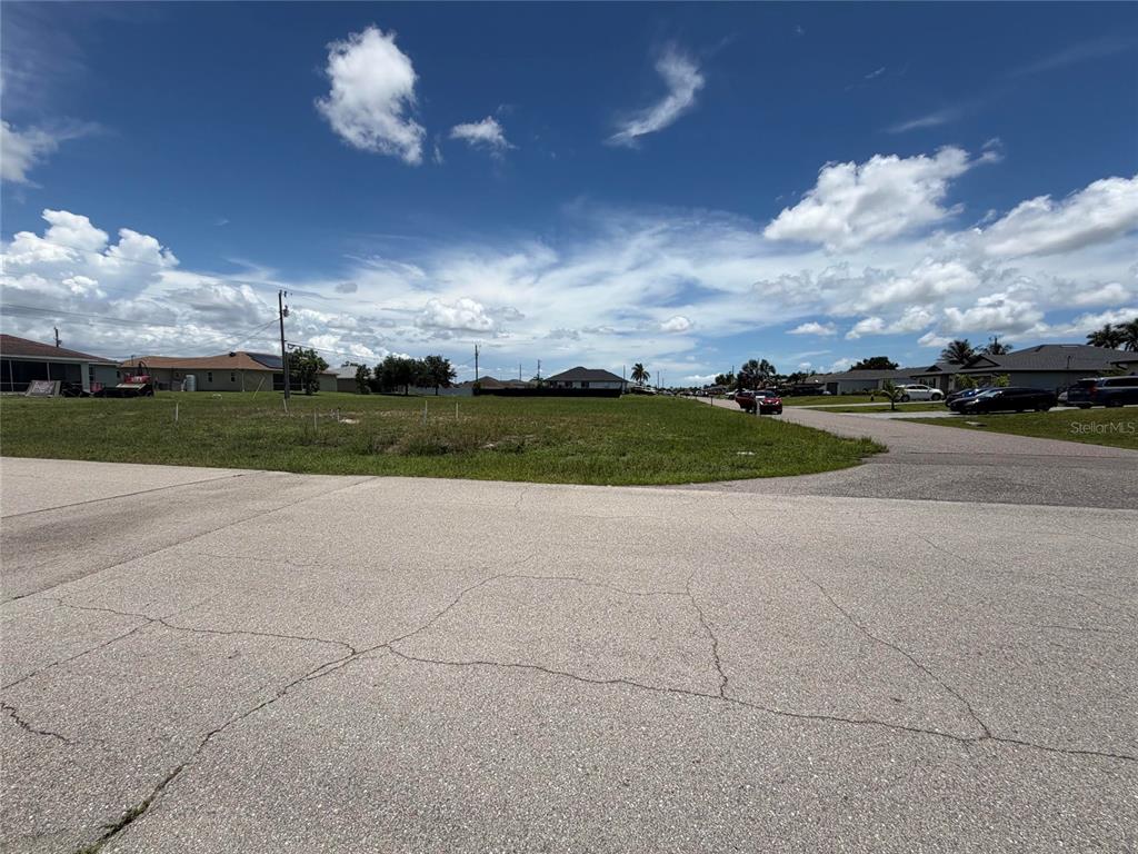 A vacant grassy corner lot sits at the intersection of two paved residential streets — 2829 NE 5TH AVENUE, CAPE CORAL, FL