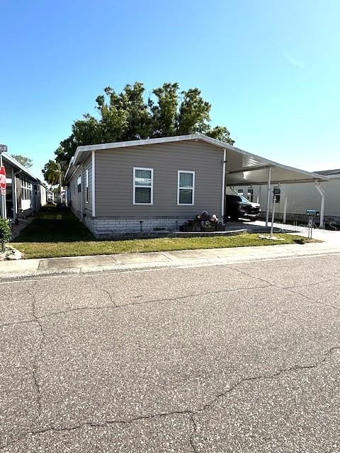 A single-story manufactured home features gray siding, a carport, and a small front yard — 1001 STARKEY RD. UNIT # 731, LARGO, FL