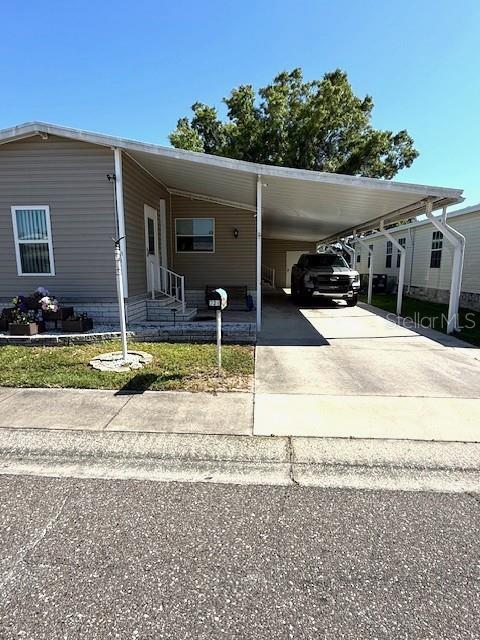 A single-story manufactured home features a large attached carport and a paved driveway — 1001 STARKEY RD. UNIT # 731, LARGO, FL