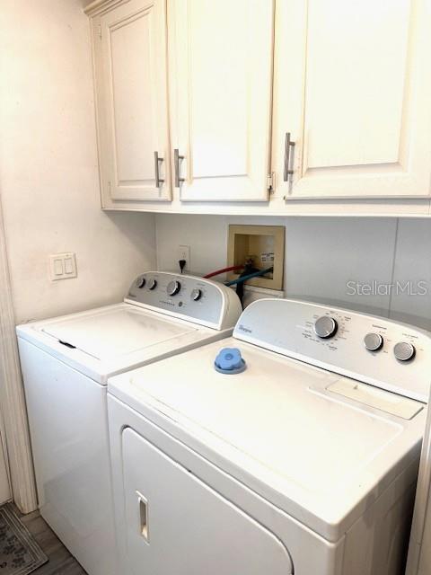 A laundry room features a white washer and dryer beneath white upper cabinets — 1001 STARKEY RD. UNIT # 731, LARGO, FL