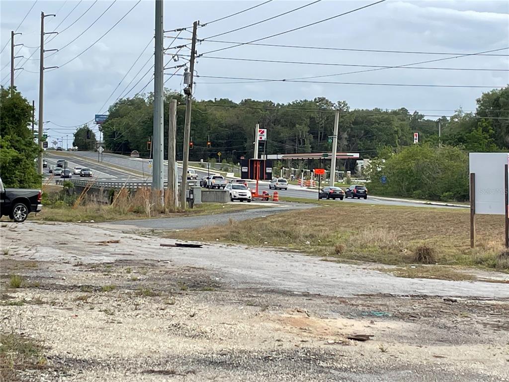 A view of a road intersection with a gas station and utility poles — 2011 US HIGHWAY 441/27, FRUITLAND PARK, FL