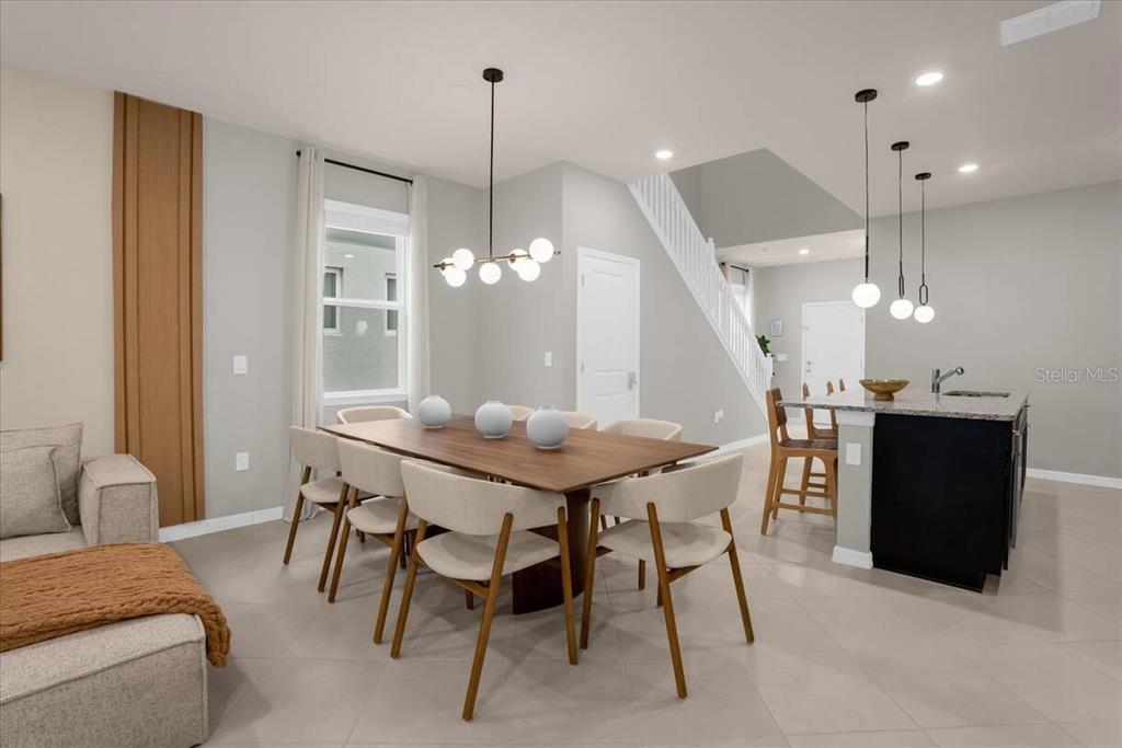 A dining area with a wooden table, six chairs, and a kitchen island with stools — 16225 SAINT KITTS CIRCLE, CLERMONT, FL